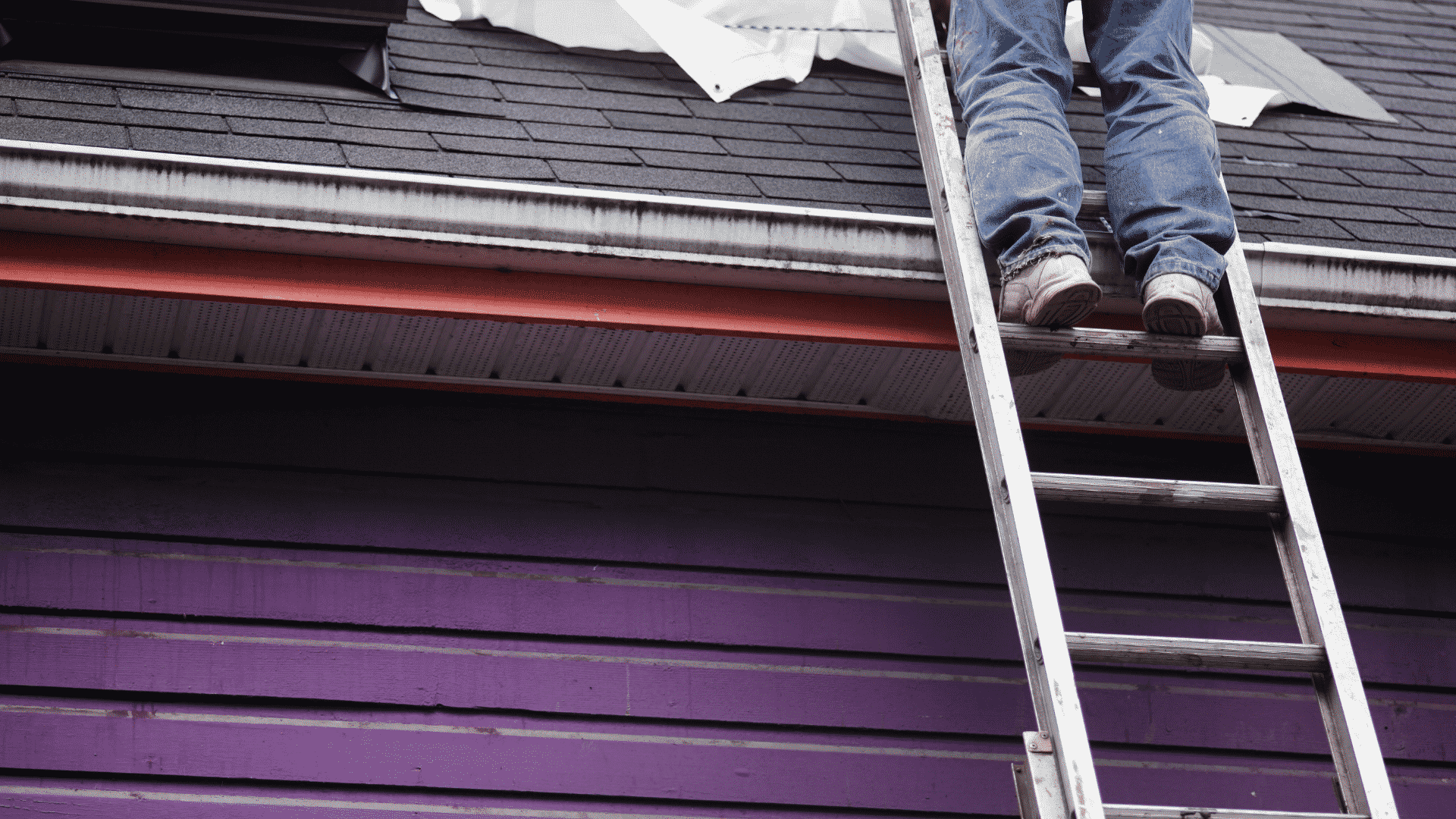 man on ladder performing roof repairs