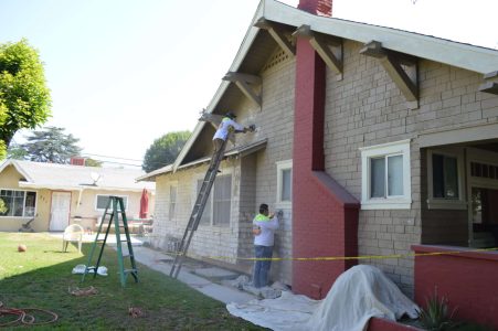 GCR employees cleaning brick on house